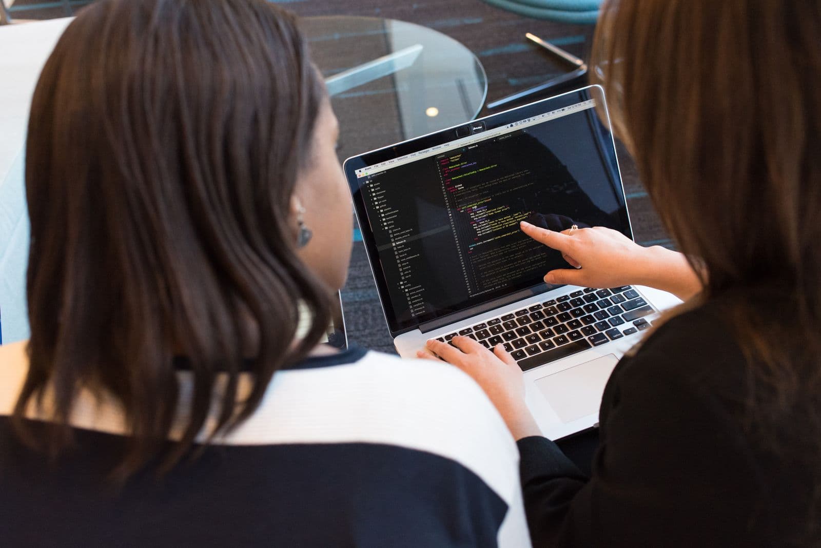 Two engineers reviewing code together on a laptop